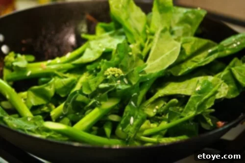Fresh Chinese Broccoli (Gai-Lan) being stir-fried in a hot wok