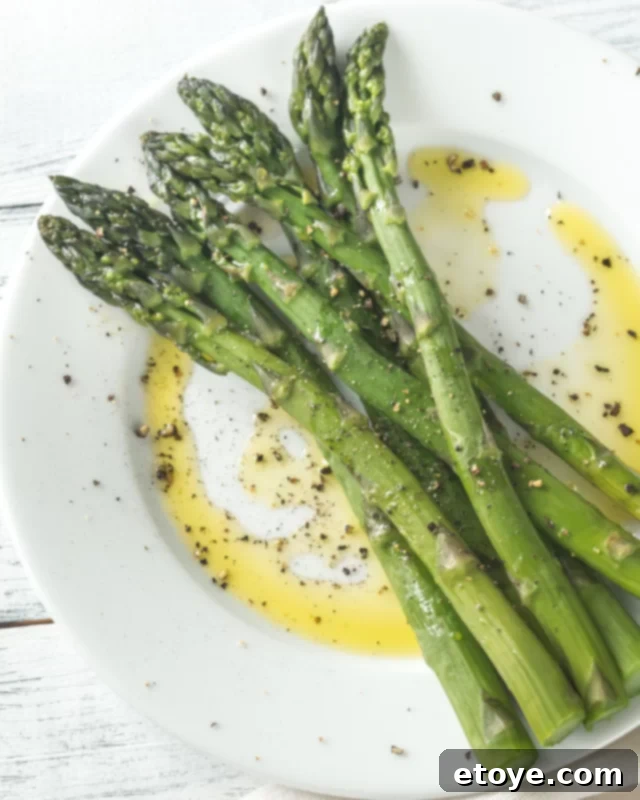Fresh asparagus spears in a microwave-safe bowl, ready for steaming