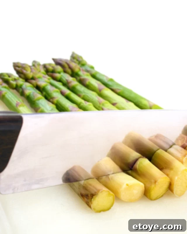 Steamed asparagus garnished with lemon, olive oil, salt, and pepper on a white plate