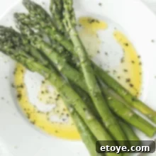 Steamed asparagus with olive oil, salt and pepper on a plate