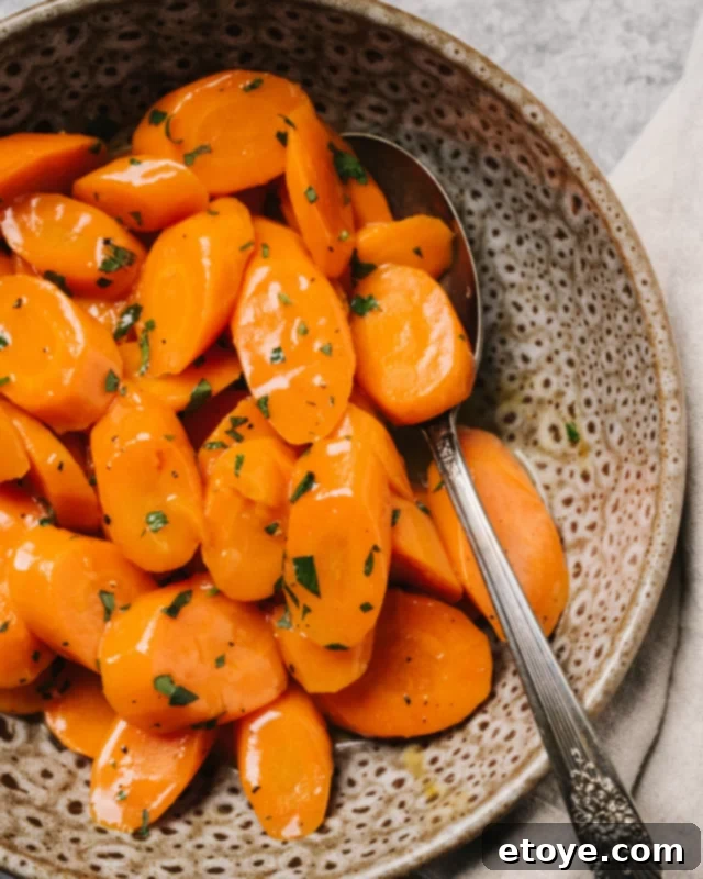Freshly steamed carrots in a bowl, ready to be seasoned.