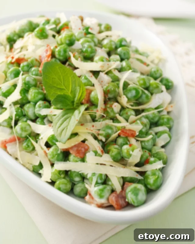 A bowl of microwave steamed peas, garnished with fresh herbs