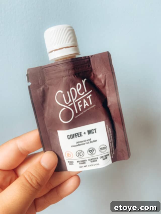 SuperFat Review and Win Your Own 3 SuperFat nut butter pouch being drizzled over a bowl of breakfast or snack