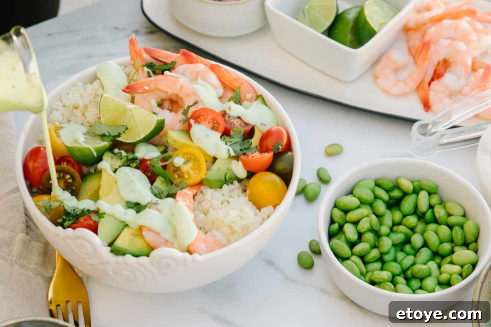 Creamy Cilantro Shrimp and Avocado Buddha Bowl 7 Shrimp avocado Buddha bowl generously drizzled with creamy cilantro lime crema, garnished with fresh cilantro and lime wedges.