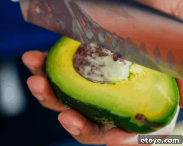Avocado Slicing Made Simple 5 Knife inserted into an avocado pit, ready for twisting