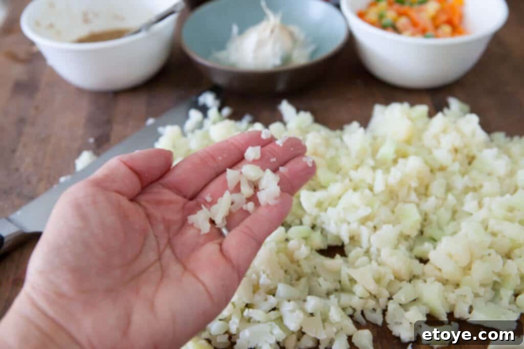 Another perspective of chopping cauliflower into rice-sized pieces