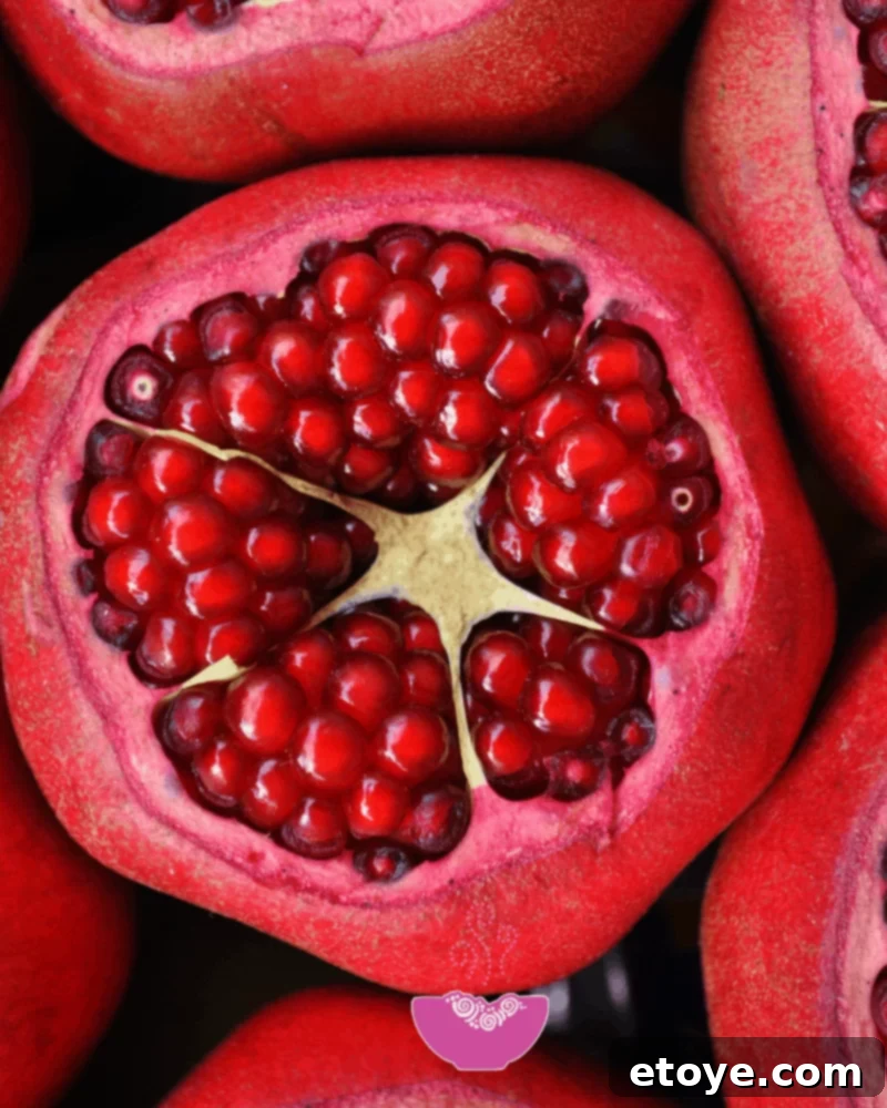 Vibrant red pomegranate halves revealing juicy arils