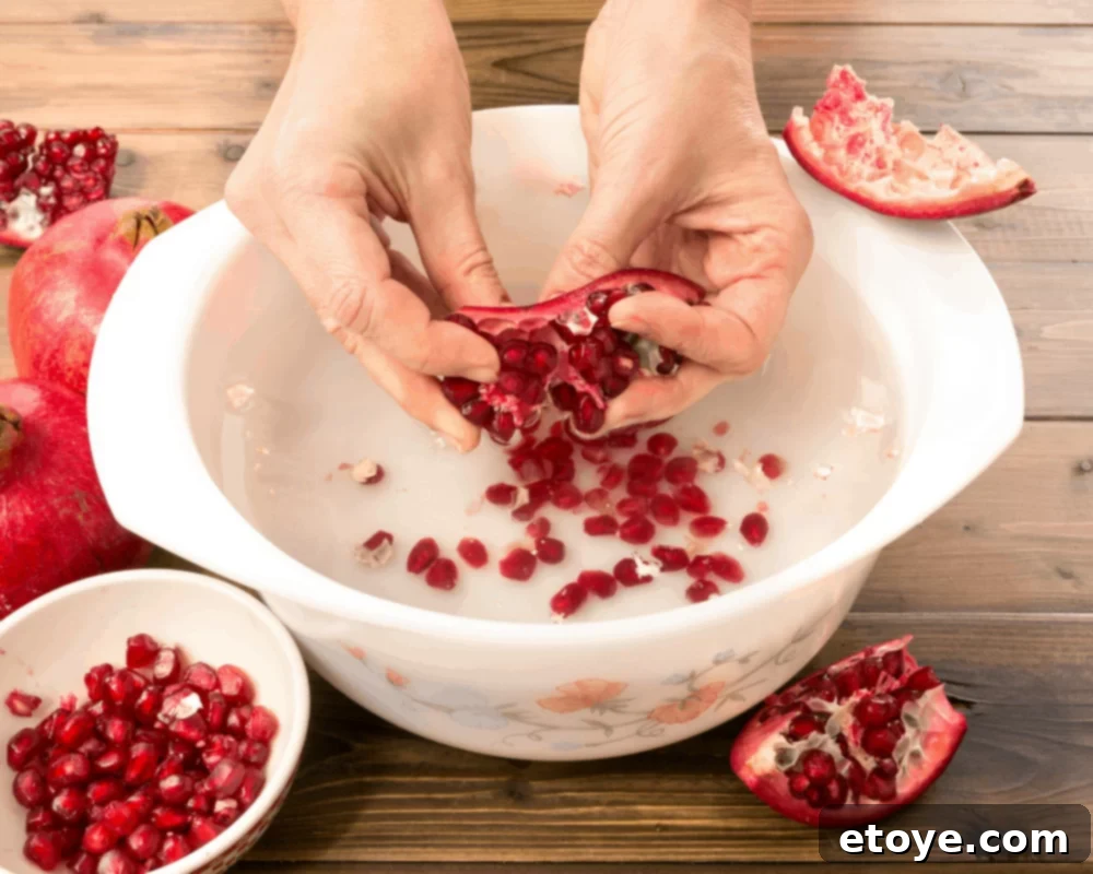 Woman removing pomegranate seeds using the underwater method