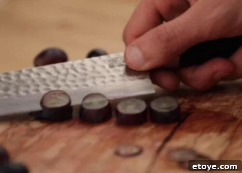 The KOTAI Kiritsuke Chef Knife in action, expertly slicing through a vibrant array of fresh vegetables, vividly demonstrating its exceptional sharpness and precision in culinary tasks.