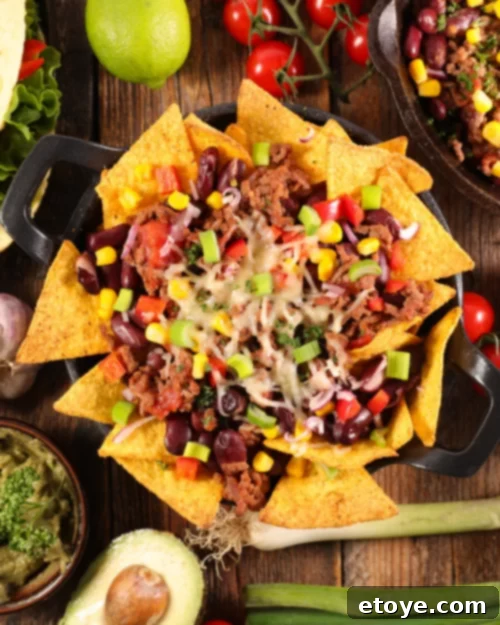 An irresistible skillet of loaded nachos featuring generous amounts of leftover brisket, melted cheese, and fresh toppings.