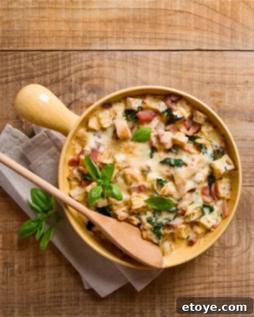 savory bread pudding with cheese and basil in a yellow casserole dish