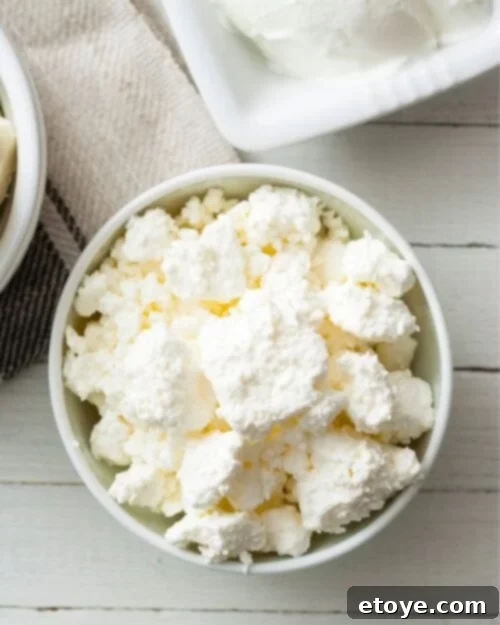 Making the Most of Sour Milk 6 Homemade ricotta cheese in a white bowl with a spoon