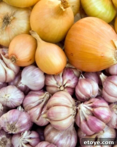 Assortment of root vegetables including potatoes, onions, and garlic, symbolizing long-term storage