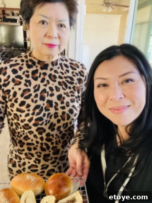 Soft & Sweet Chinese Coconut Buns 3 Author's mother, an expert baker, smiling brightly while holding a freshly baked Chinese bun.