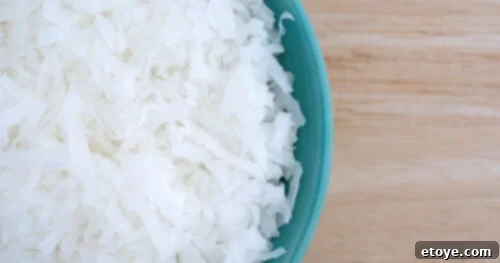 Soft & Sweet Chinese Coconut Buns 4 Close-up of fluffy, white sweetened coconut flakes in a bowl, often used in American baking for its added sweetness.