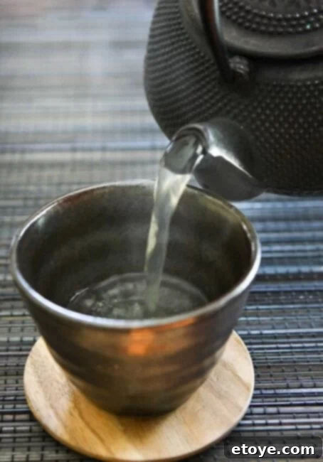 matsutake-dobin-mushi-mushroom-recipe-022 Pouring fragrant Matsutake Dobin Mushi broth into a traditional Japanese teacup