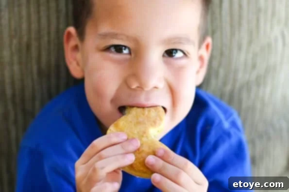 A young boy, Nathan, happily eating a buttermilk biscuit