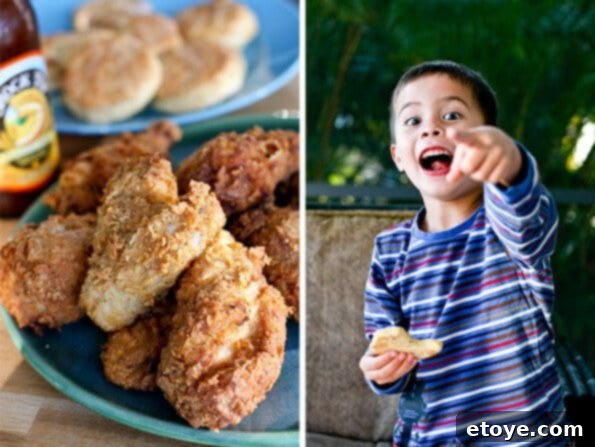 A young hand caught trying to steal fried chicken from a plate, while biscuits are nearby