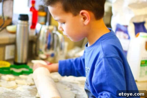 Hands mixing buttermilk biscuit dough in a bowl, preparing for shaping