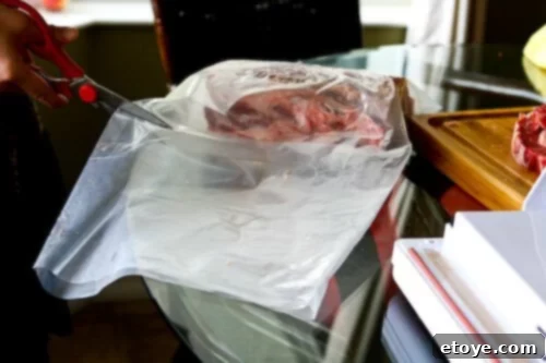 Carefully inserting the prepared beef loin into an UMAi Dry bag