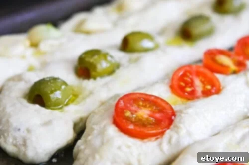 Close-up of a No-Knead Baguette loaf with cherry tomatoes embedded and sprinkled with salt