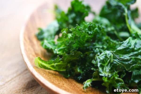 Close-up of baked kale chips in a wooden bowl, ready to be served