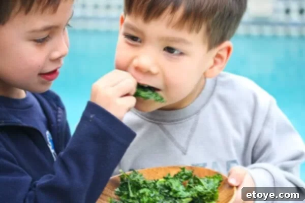 A person happily eating crispy kale chips directly from a bowl
