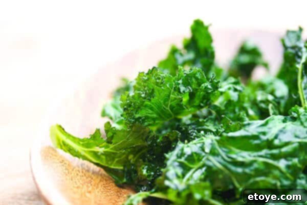 Fresh kale leaves neatly arranged on a white plate
