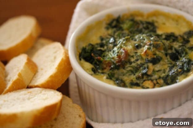 Warm Spinach Mascarpone Dip served in a small bowl with crispy bread slices and fresh celery sticks, ready to be enjoyed as a gourmet appetizer