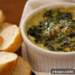 Beautifully arranged serving of Warm Spinach Mascarpone Dip with various dippers like bread and vegetables, ready for a party