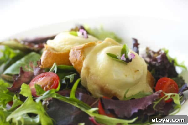 Warm goat cheese rounds melting on toasted baguette slices, arranged on a rustic plate.