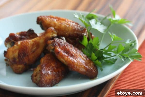 Close-up of golden brown, caramelized smoky sweet chicken wings on a serving plate