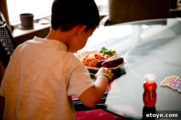 A child stealthily grabbing a grilled sausage with his hand