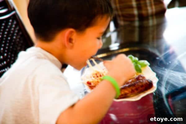 A child covertly eating a grilled sausage, trying not to be seen