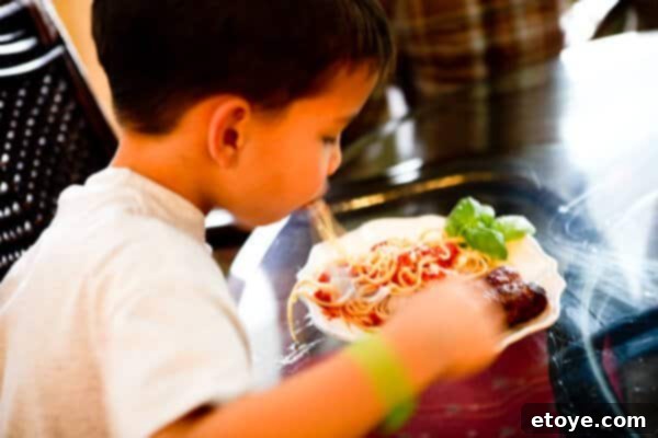 A close-up of a child intensely slurping a sausage, showing humorous 'slurptastic' action