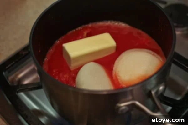 Marcella Hazan's tomato sauce simmering gently on the stovetop, with butter and onion