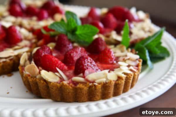 Luscious Strawberry Almond Cream Tart 2 Delicious Strawberry Almond Cream Tart with fresh strawberries and almond slivers, perfect for summer dessert