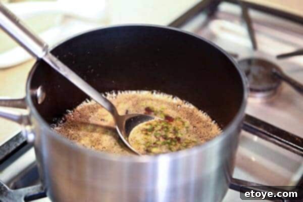 Signature Cola Wings 5 Finely minced jalapeno being stirred into the simmering cola glaze