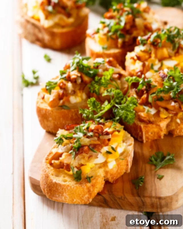Fourth of July Feast Favorites 3 Gourmet crostinis topped with creamy cheese, crispy bacon, and fresh herbs on a rustic wooden cutting board.